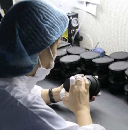 Cleanroom technician assembling precision optical components
